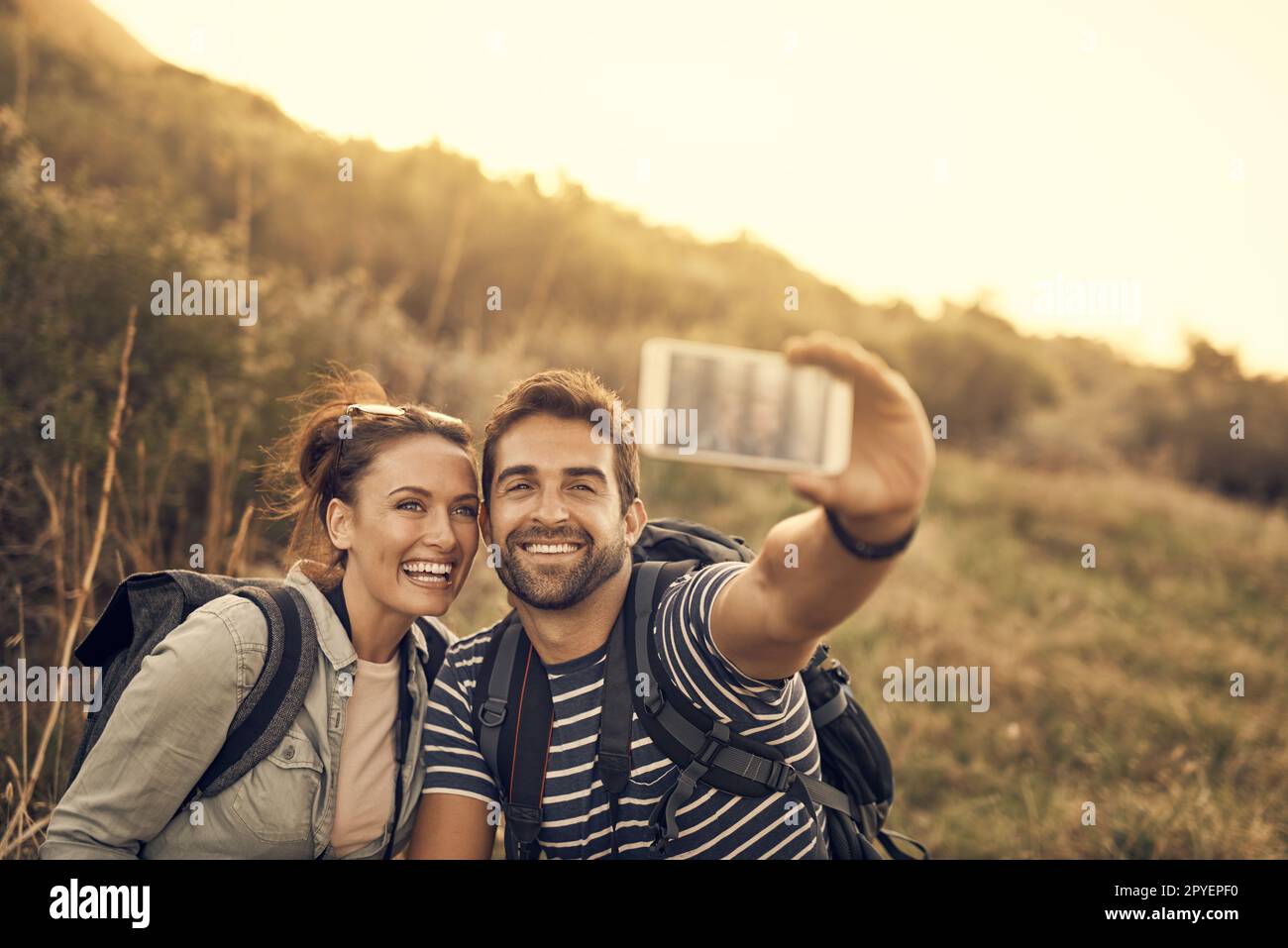 This is a date to be remembered. a happy couple taking a selfie while out on a hiking trip. Stock Photo