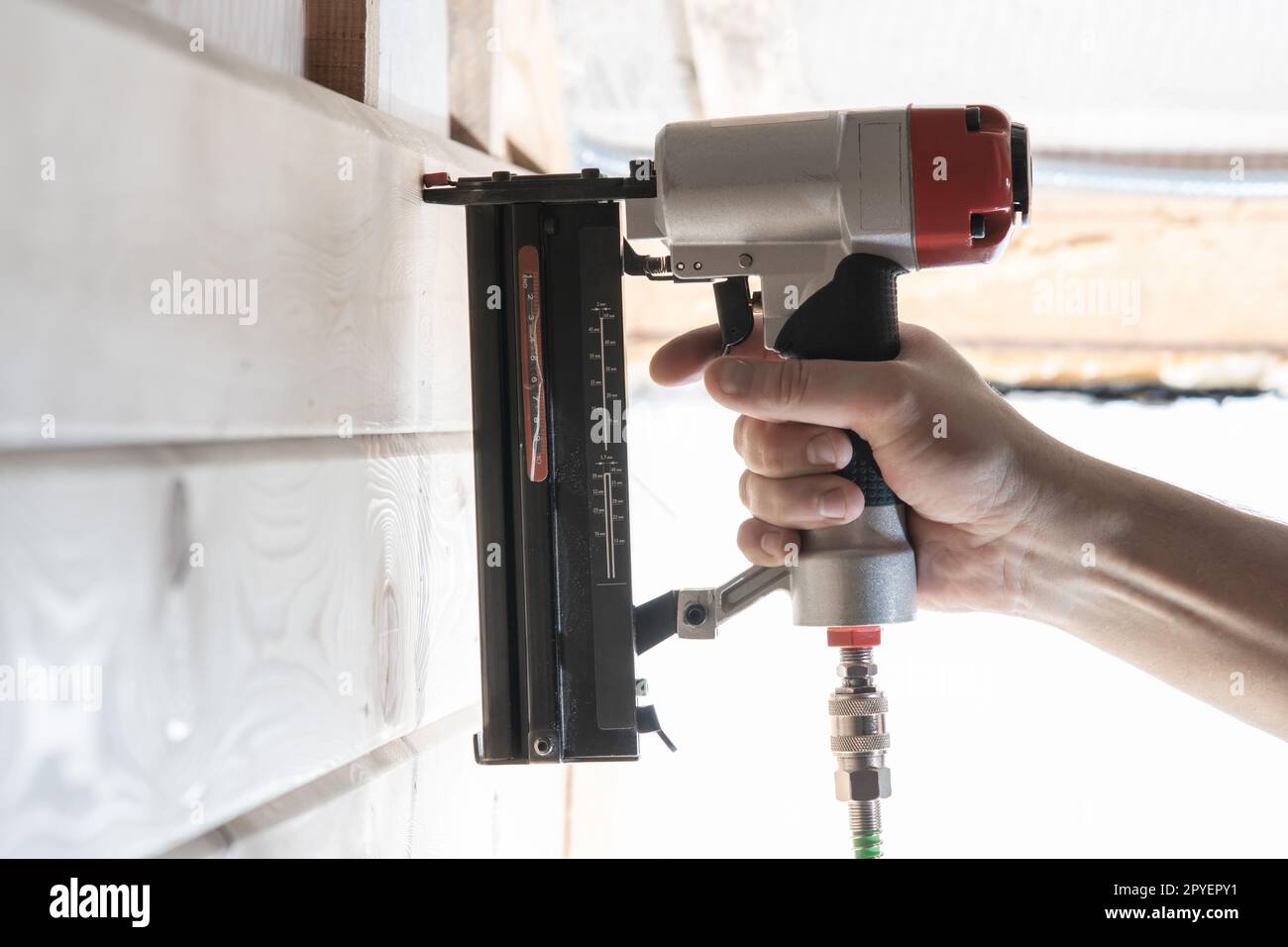 Unrecognizable builder worker hand using pneumatic stapler for wooden ...