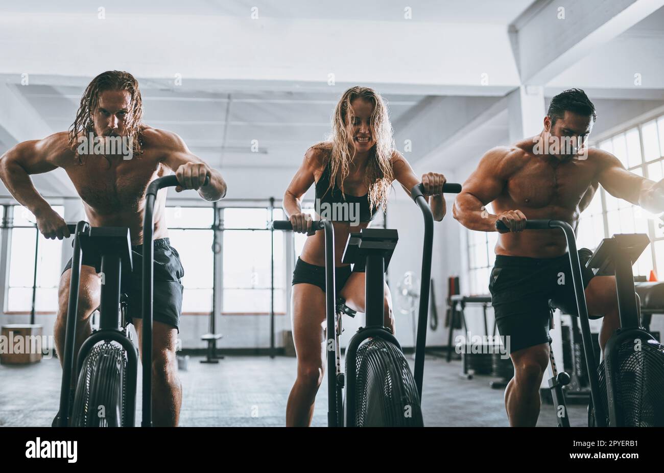 Pure dedication. three people working out on elliptical machines. Stock Photo