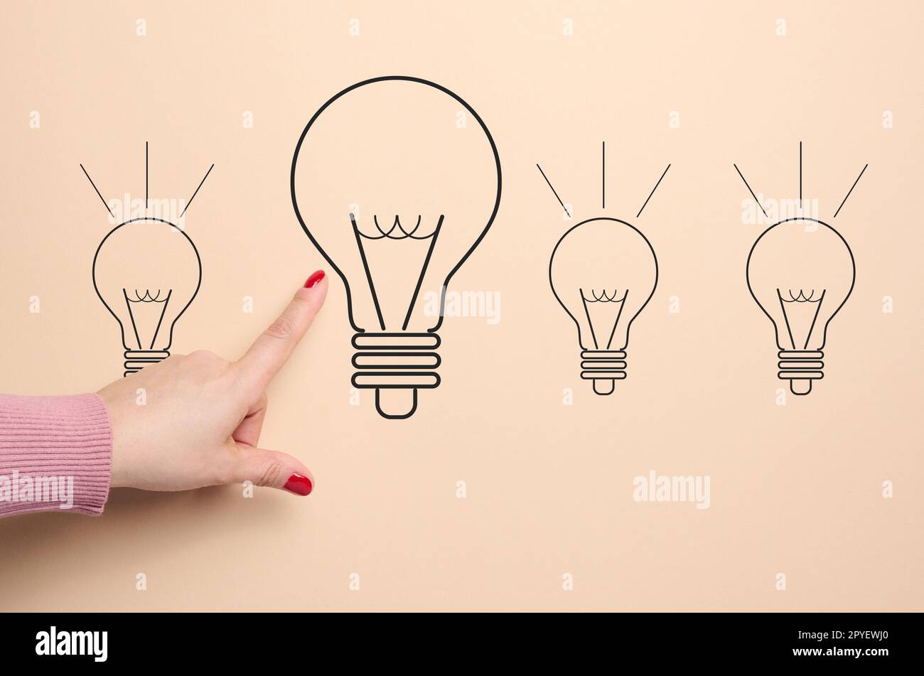 A drawn light bulb and a female hand pointing at it, concept of searching for new ideas, innovation Stock Photo