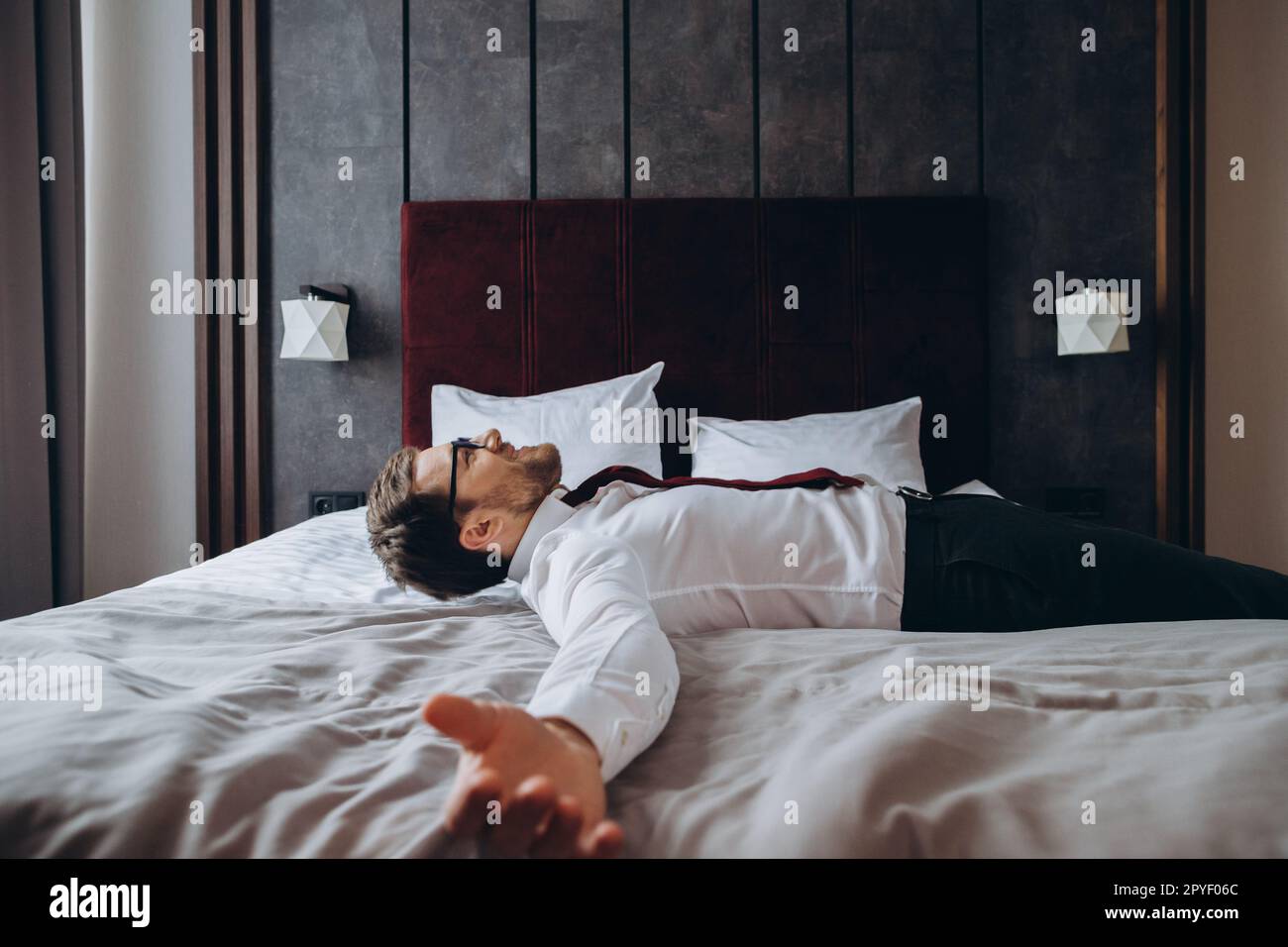 Exhausted businessman resting on bed after long air flight, jet lag