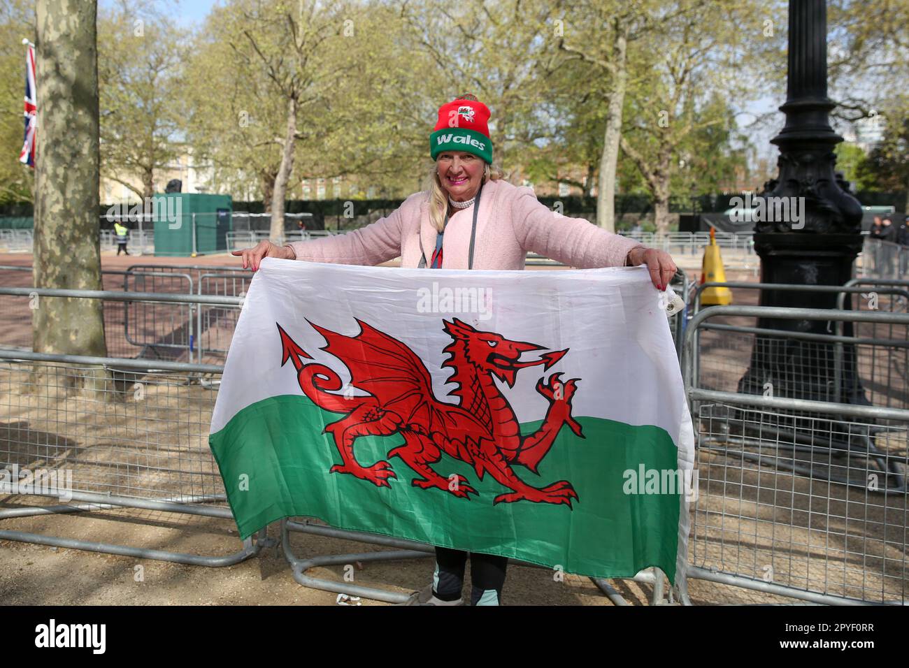 Royal fan Anne from Wales holds the flag of Wales as she camps along The Mall in central London ahead of the Coronation of King Charles III on 6 May 2023. Stock Photo