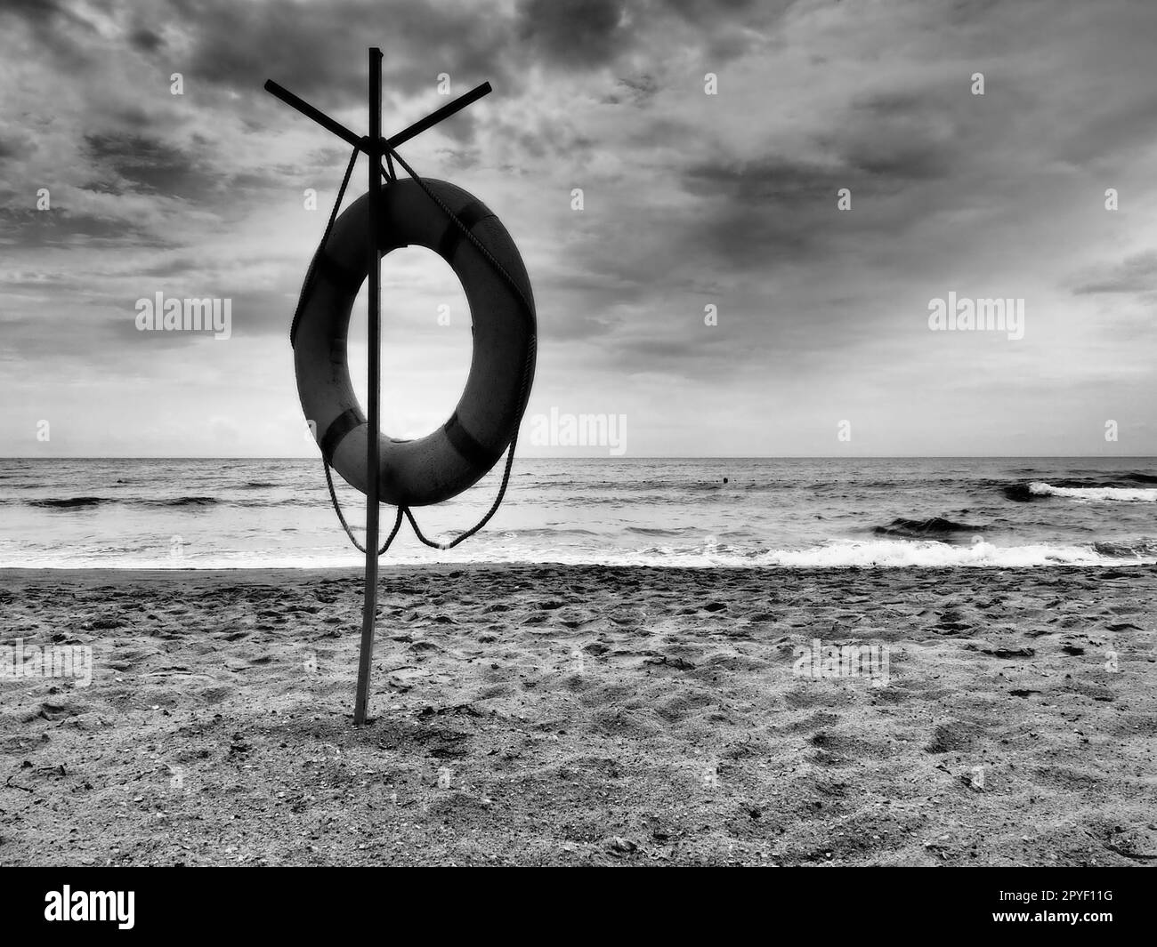 Lifebuoy on a sandy beach. Orange circle on a pole to rescue people
