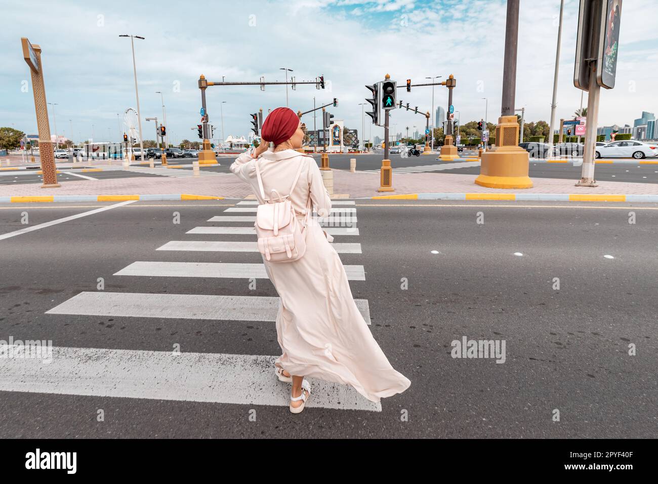 15 January 2023, Abu Dhabi, UAE: indian girl crosses the road at the