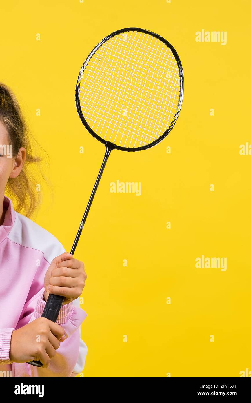 Full length studio photo of ten year old girl holding badminton racket