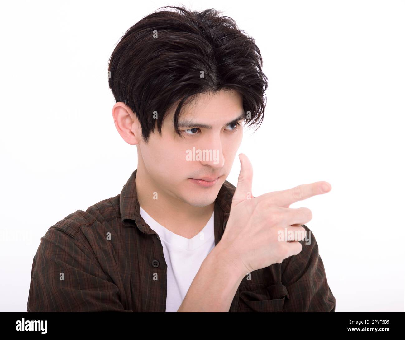 Young man looking and pointing to empty space Stock Photo