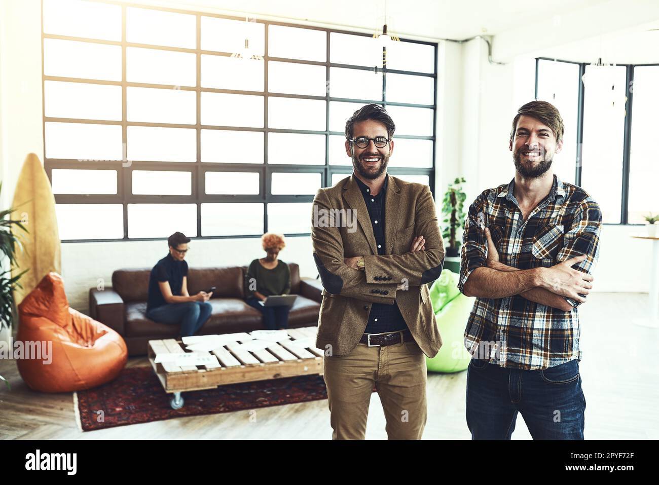 We prefer succeeding together. two designers standing in a modern office. Stock Photo