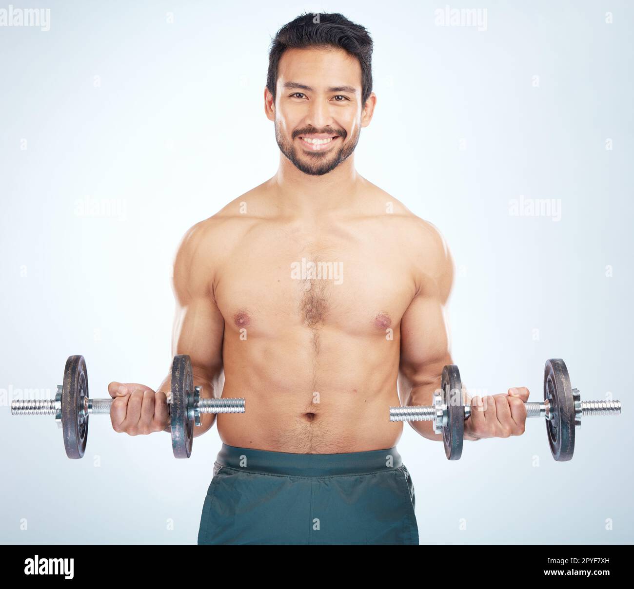 Portrait, fitness or man training with dumbbell in workout or exercise in studio for strong arms, biceps or body goals. Muscles, mindset or happy bodybuilder sports athlete weightlifting with mock up Stock Photo