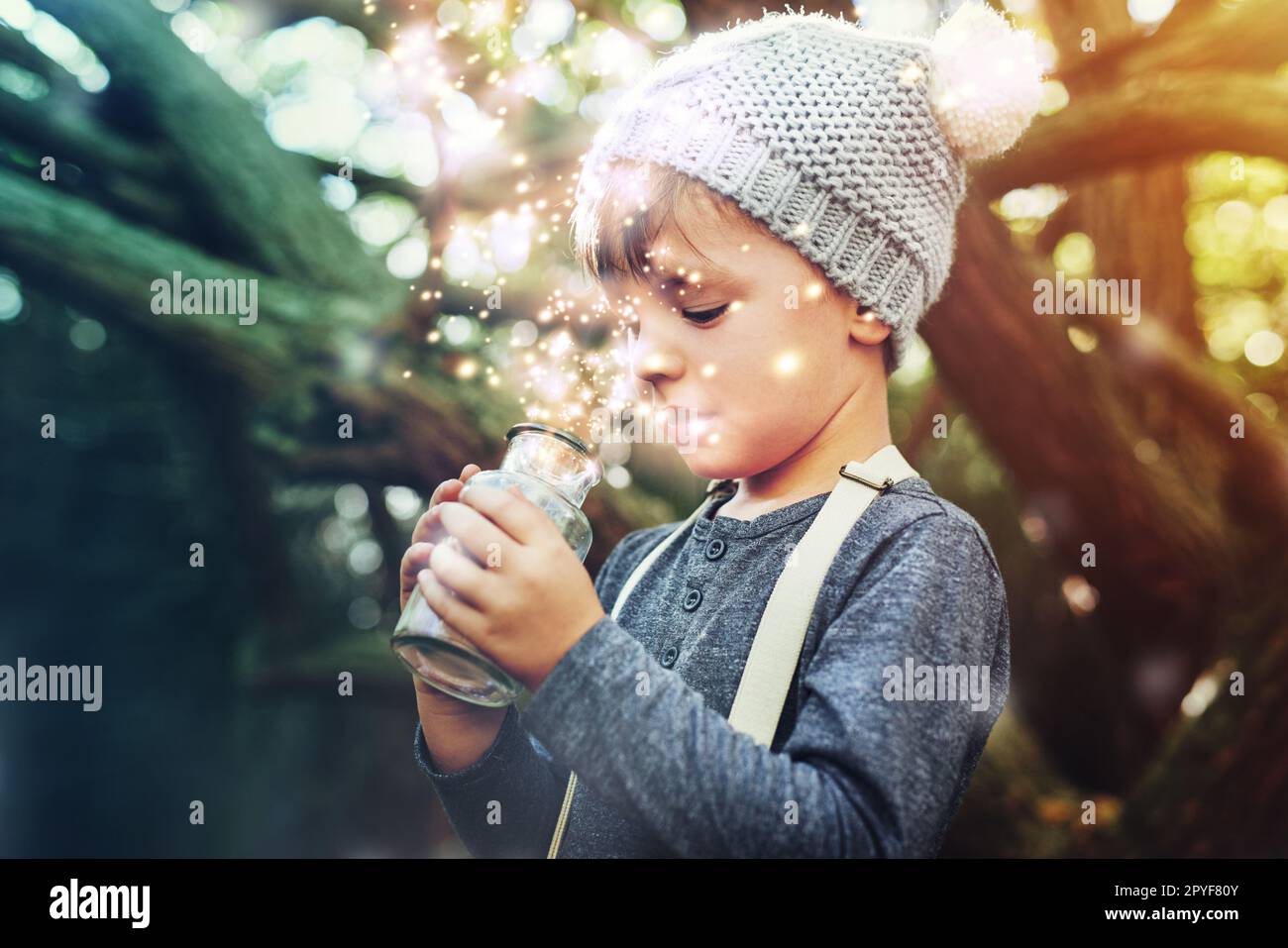 What magic is this. a little boy catching fireflies in a jar outside. Stock Photo