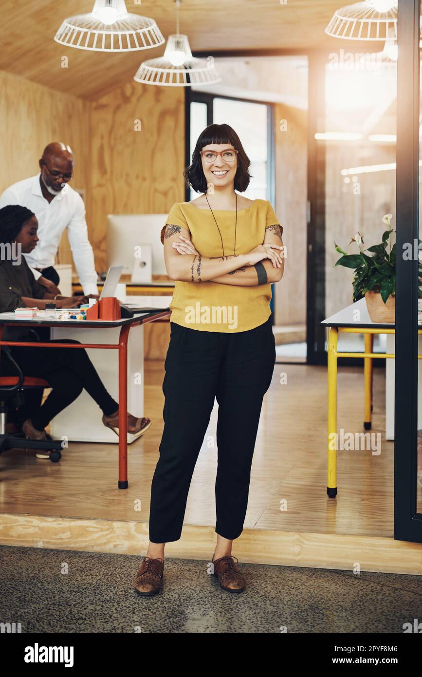 She has a lot to offer. a creative businesswoman standing in her office with colleagues blurred in the background. Stock Photo
