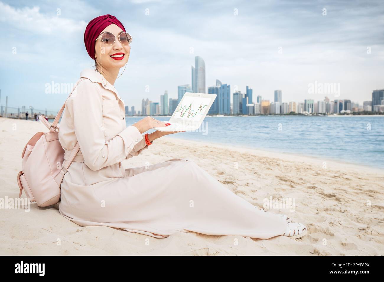 Asian girl working on laptop with stock market exchange online graph