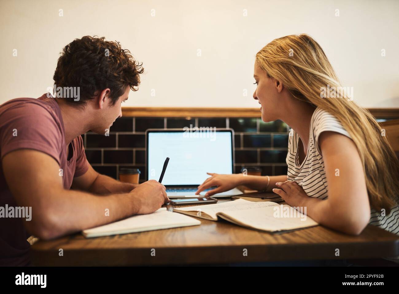 Watching an online tutorial together. two happy young students having a