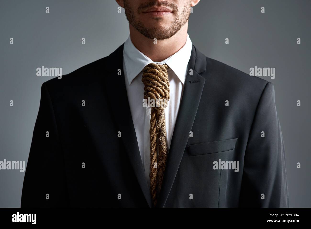 Have you become a slave to business. Cropped studio shot of a businessman with a noose tied around his neck for a tie against a gray background. Stock Photo