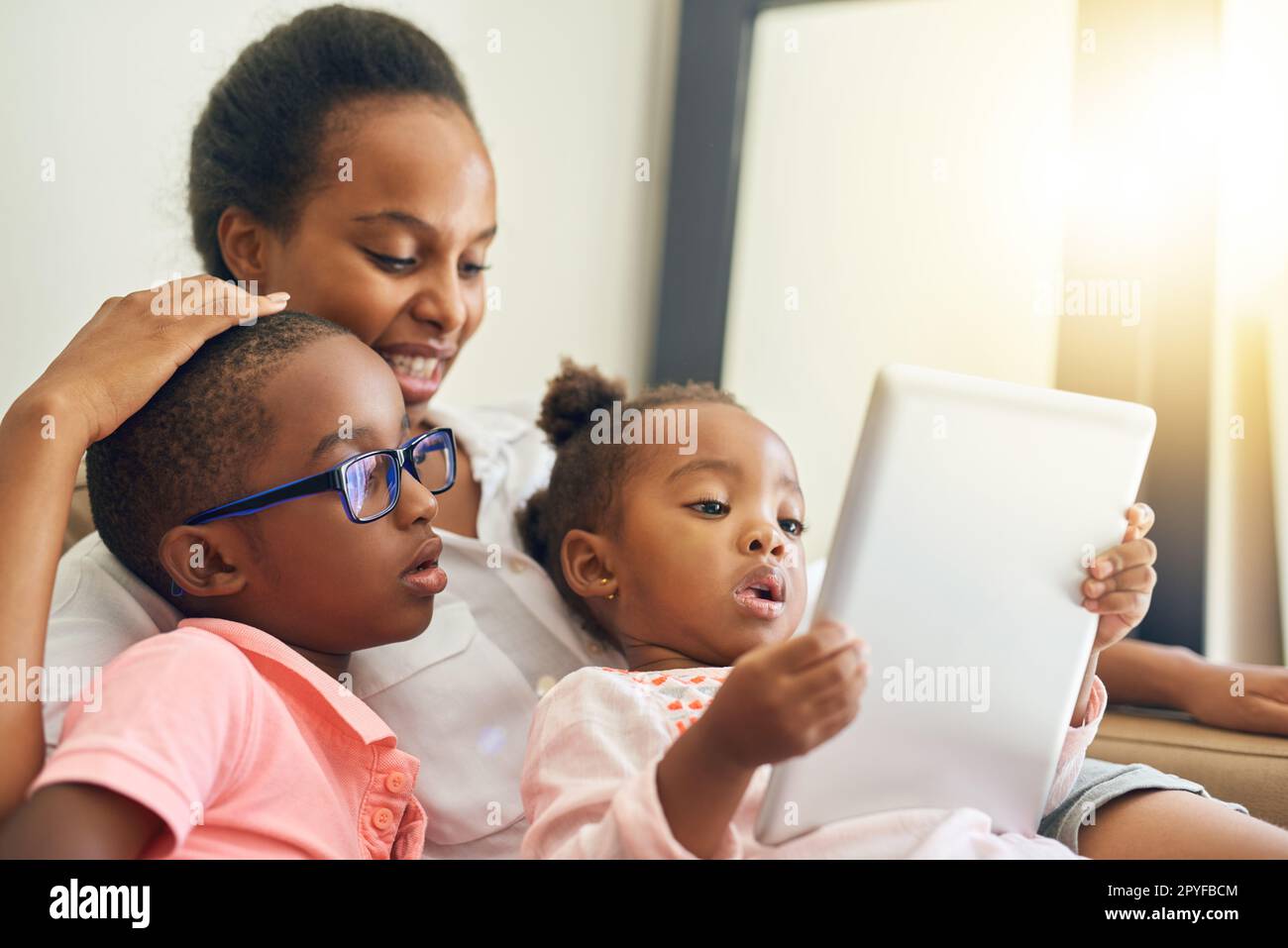 Some family down time. an affectionate young family using a tablet together at home. Stock Photo