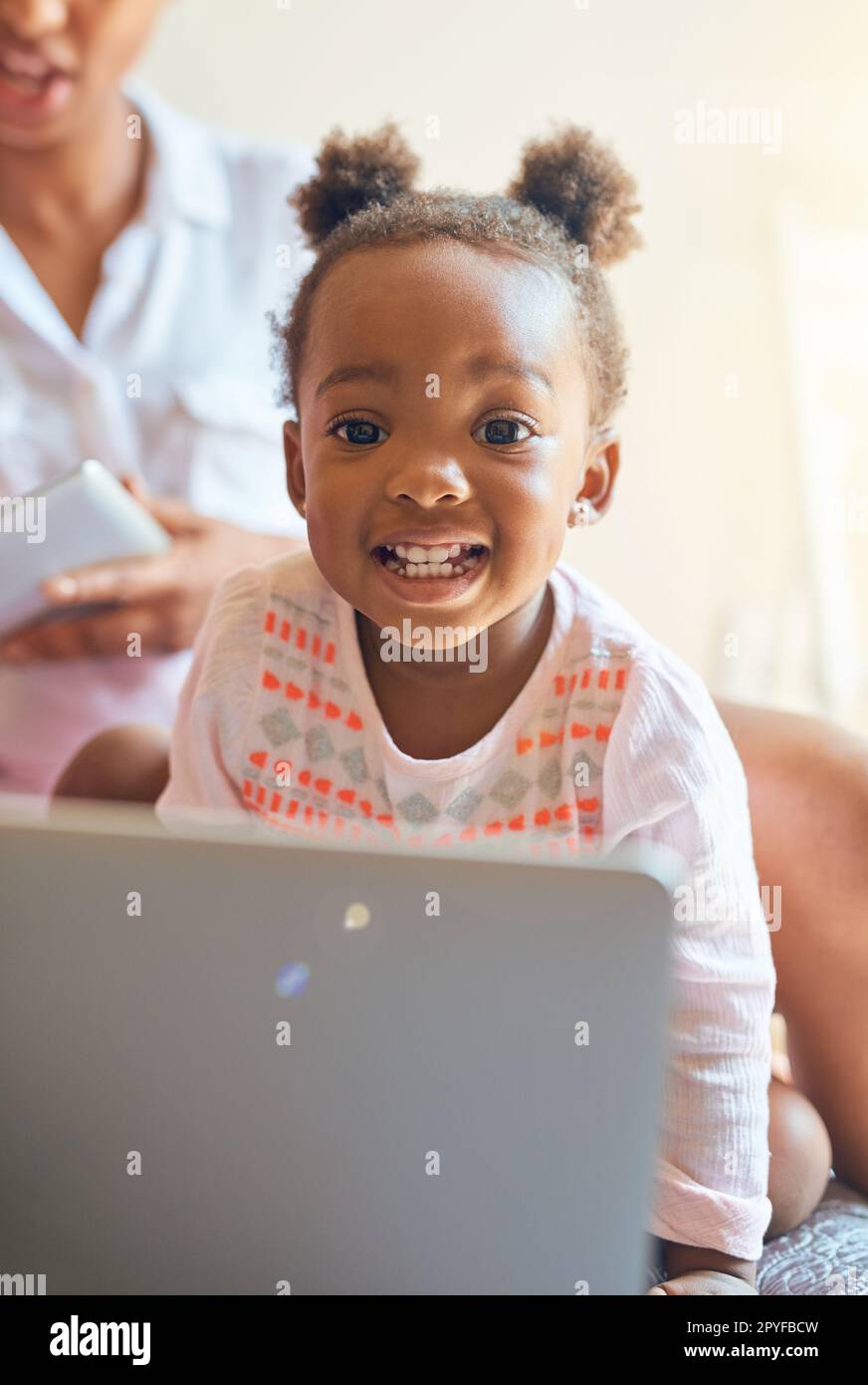 Shes a tech-savvy kid. Cropped portrait of an adorable little girl playing on a laptop at home. Stock Photo