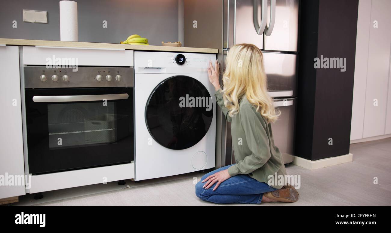 Woman Loading Dirty Clothes In Washing Machine For Washing Stock Photo