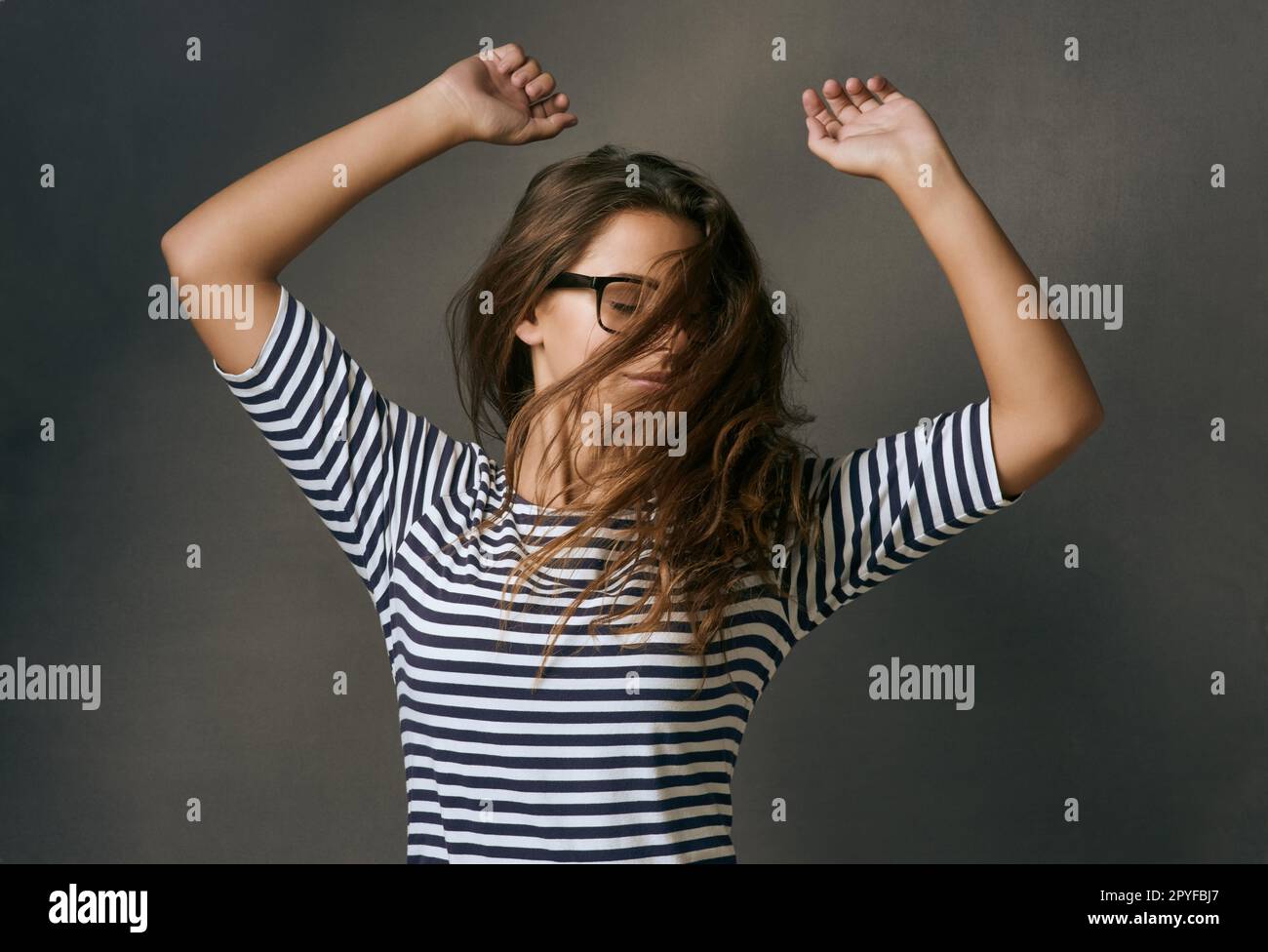 Today I choose joy. Studio shot of a young woman dancing against a dark background. Stock Photo