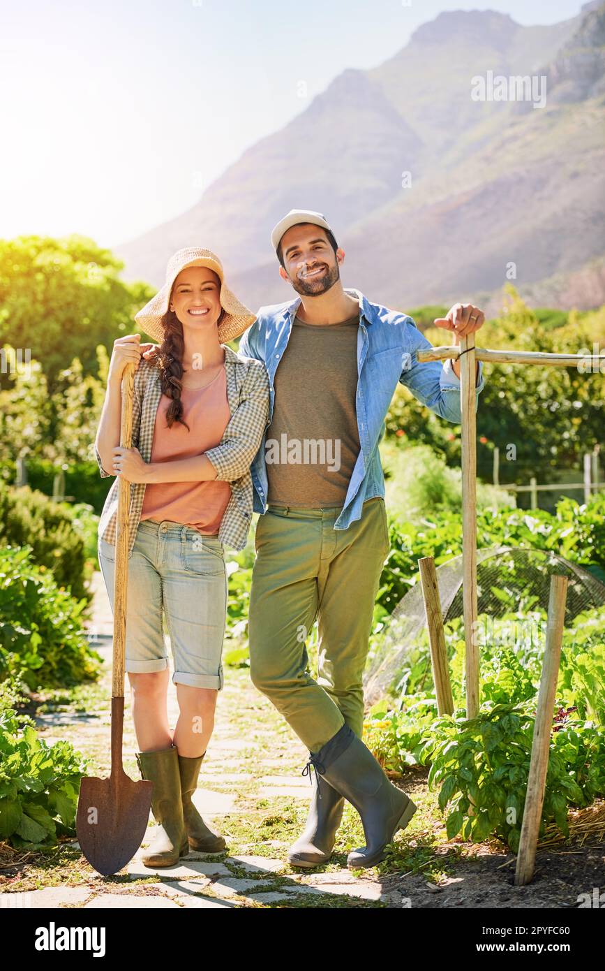 Our office has the best view. Portrait of two happy young farmers posing together in the fields