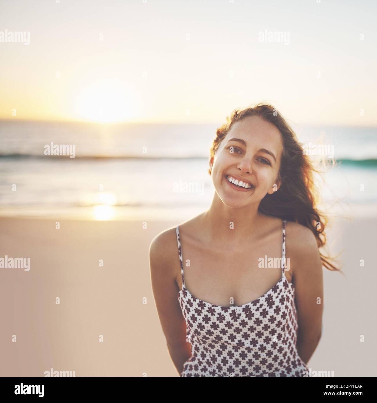 Youll find nothing but good vibes by the shore. a young woman enjoying her day at the beach. Stock Photo