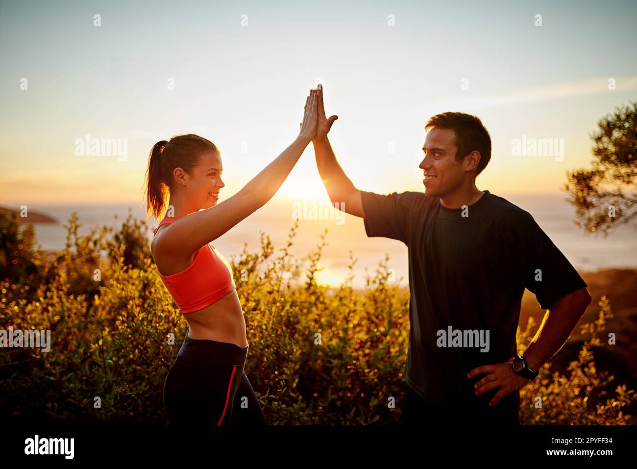 Challenges are easier to defeat together. a sporty young couple high fiving each other outside. Stock Photo