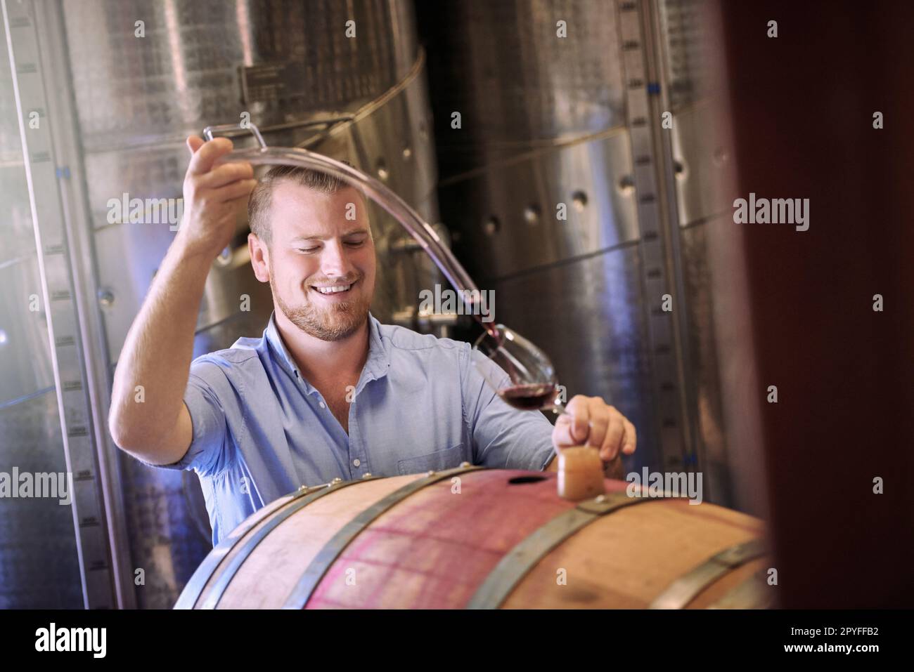Perfect for when friends drop in. a sommelier pouring a glass of wine right out the barrel. Stock Photo