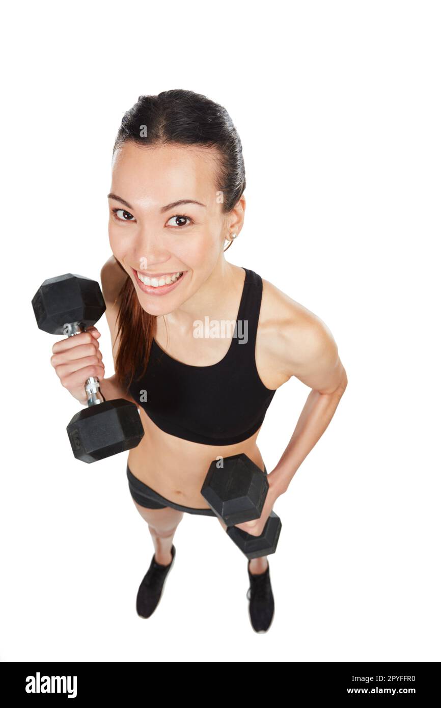 I love lifting. Studio shot of a young woman working out with dumbbells  against a white background Stock Photo - Alamy