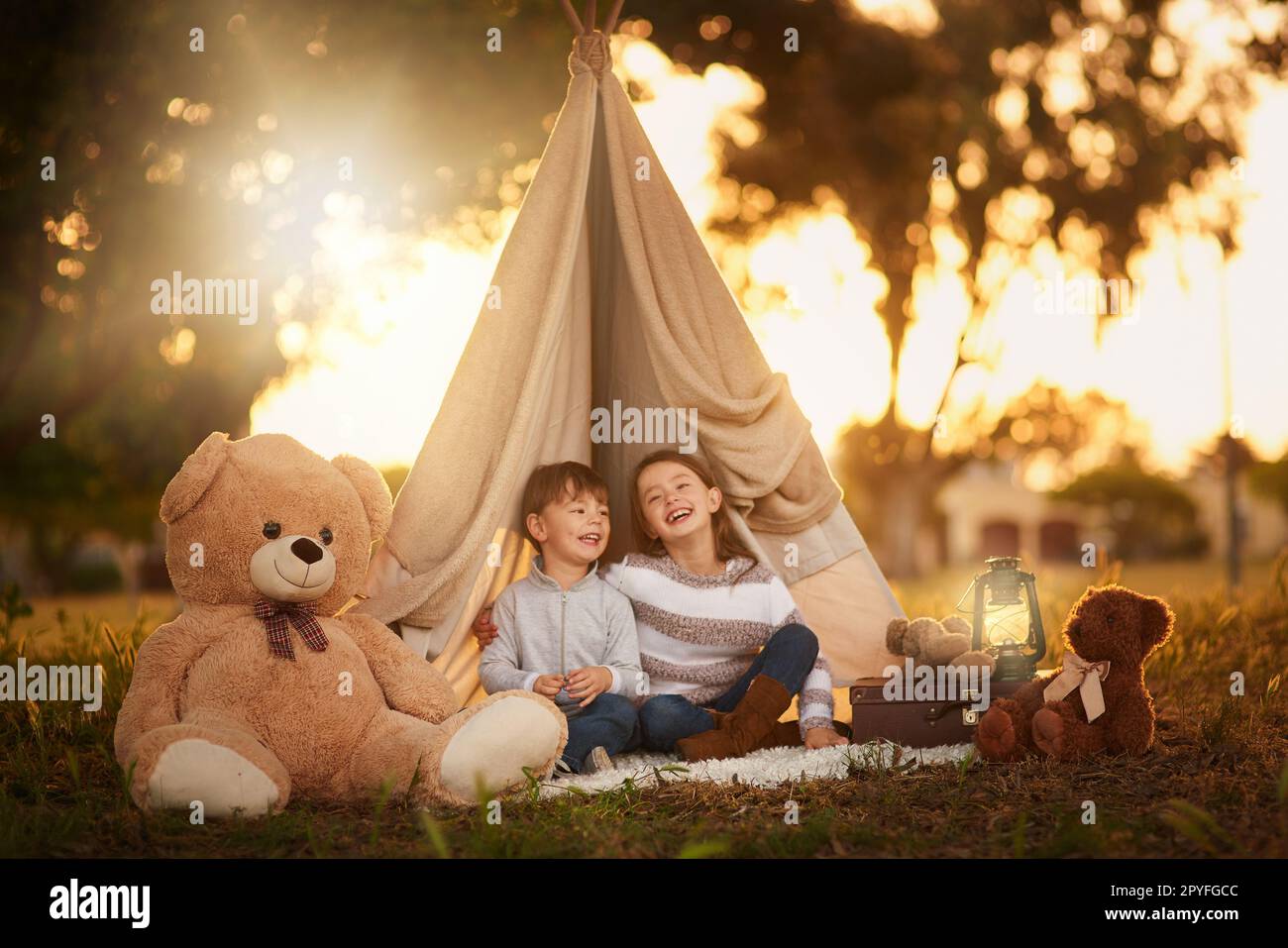 These siblings are the best of friends. two cute little siblings playing together in a teepee outside. Stock Photo