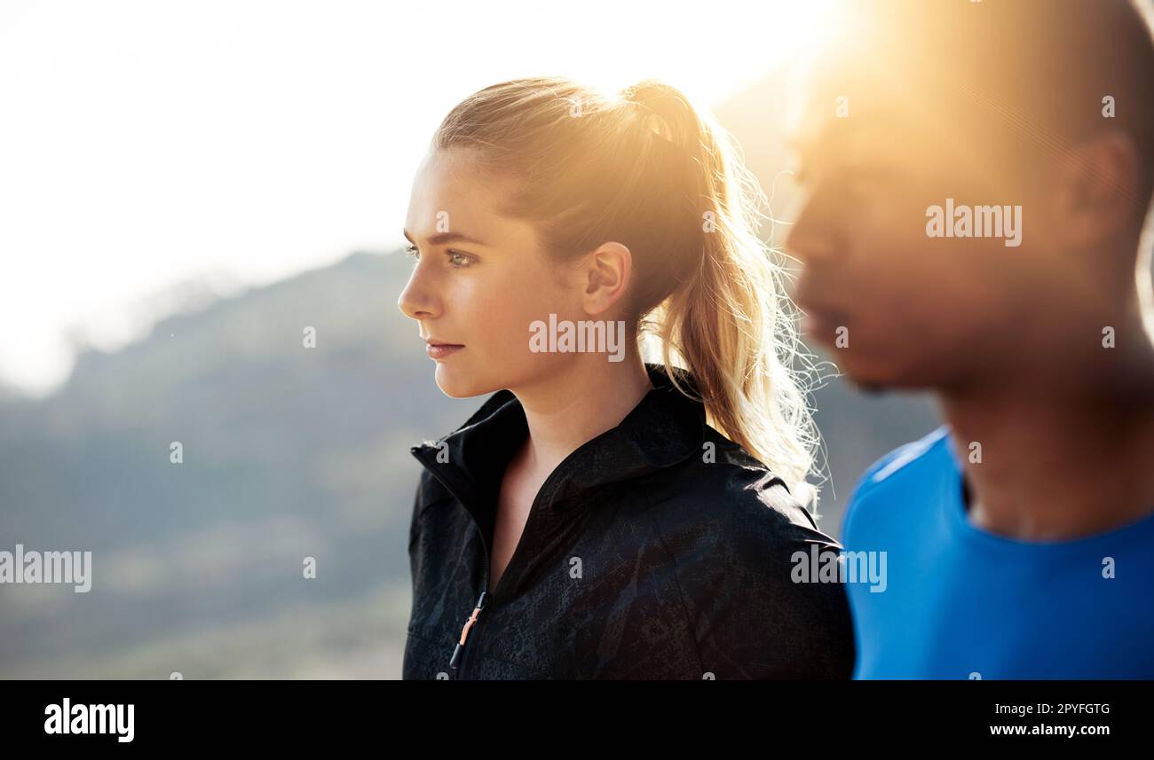 Running turns any open place into our chapel. two athletes standing outdoors. Stock Photo