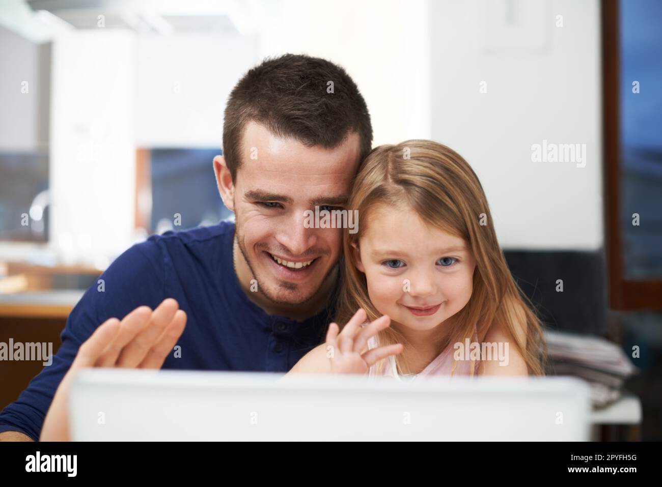 Hi grandpa and grandma. A father and his daughter connecting with family via online call. Stock Photo