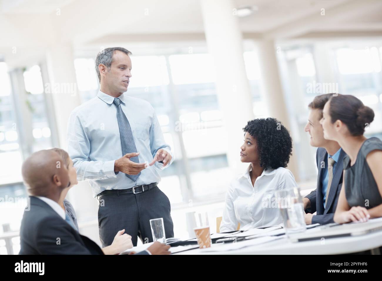Theres a few changes Id like to implement. A multi-ethnic group of business people listening to their boss during a meeting. Stock Photo