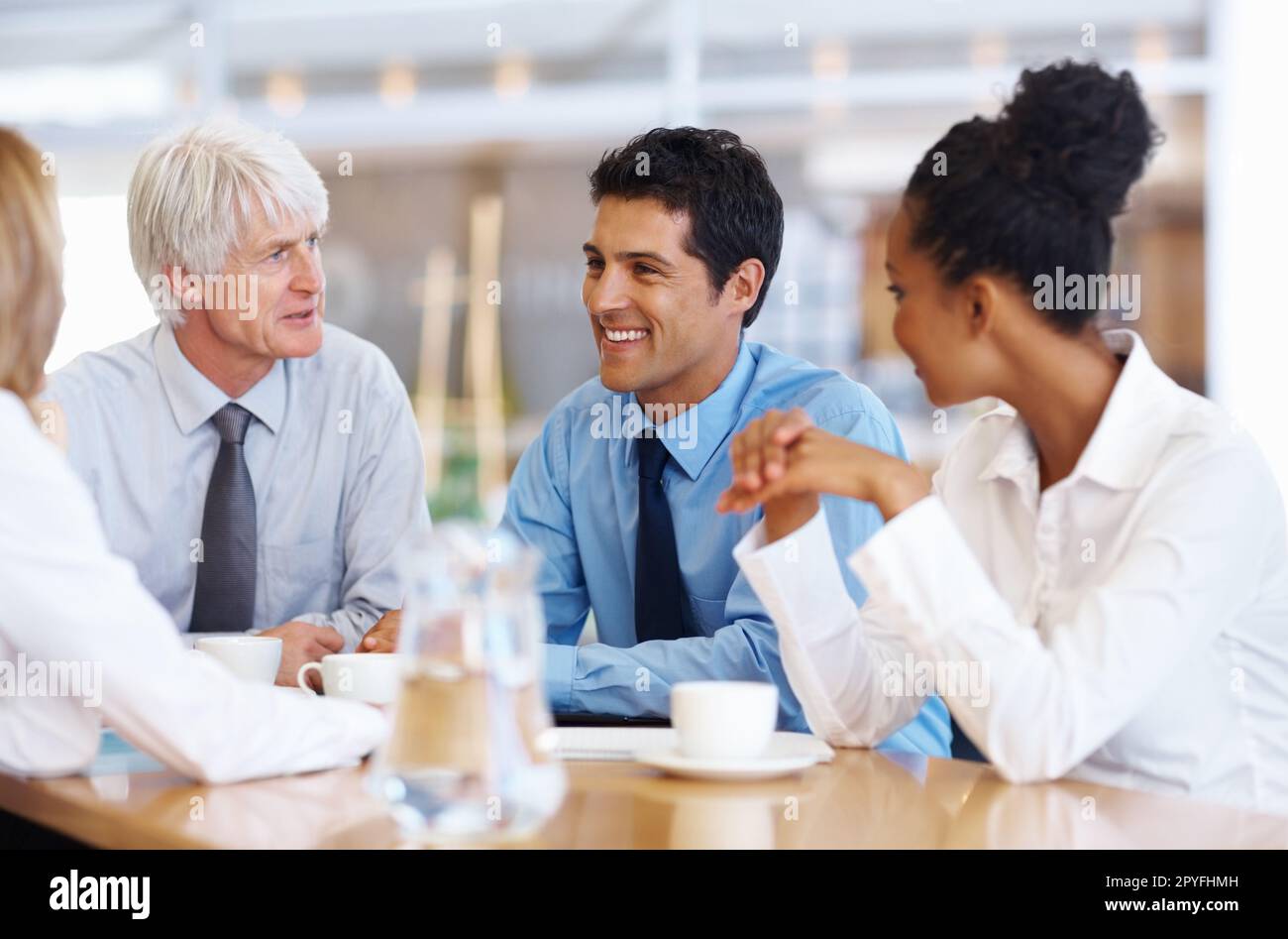 Business team having happy conversation. Portrait of multi ethnic business team having happy conversation at conference room. Stock Photo