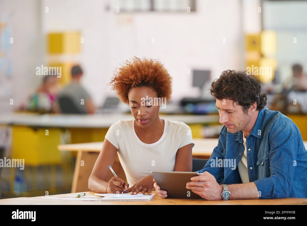 Collaborate connect and create. two coworkers using a digital tablet together in an office. Stock Photo