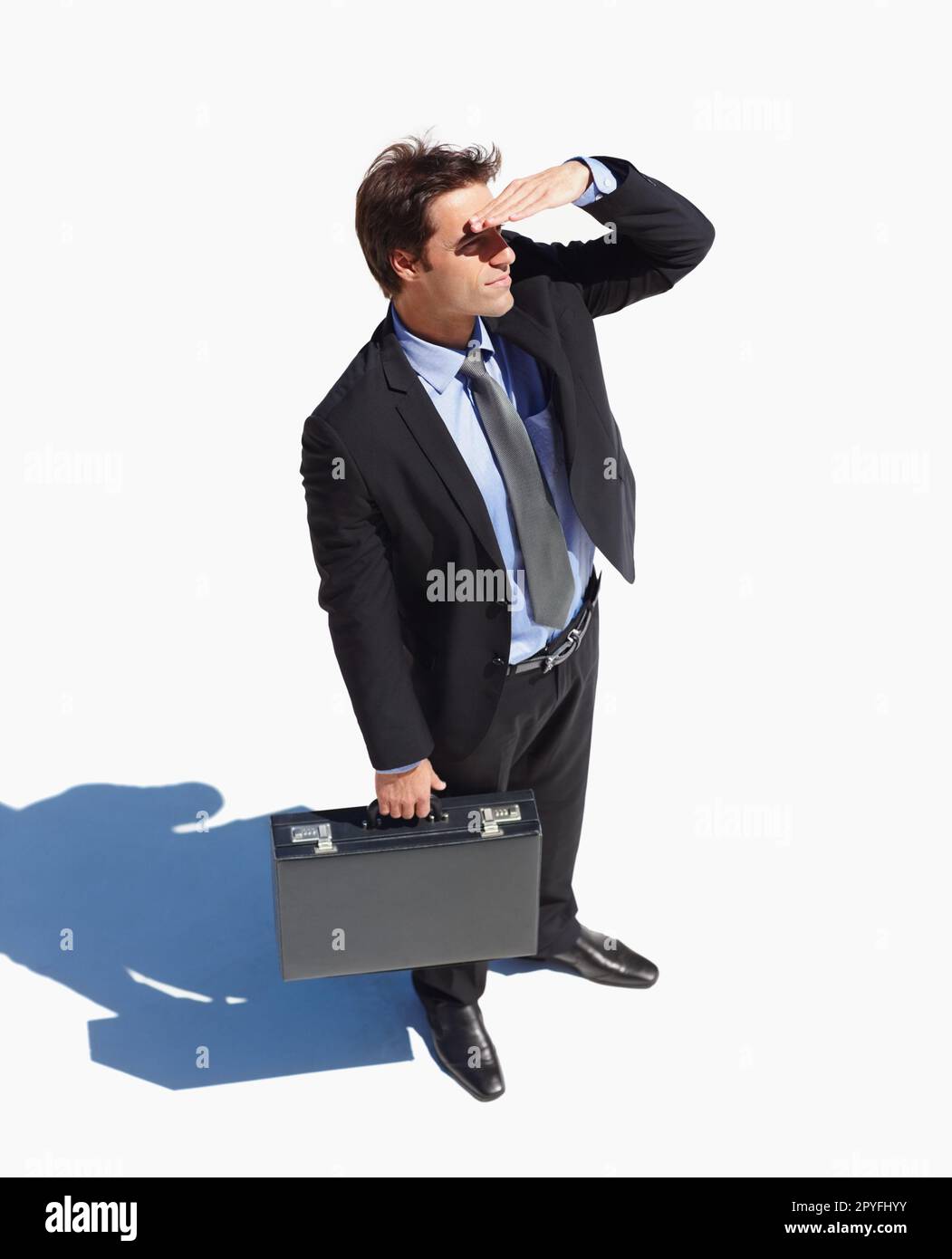 Top view of a business man shielding his eyes on a sunny day. Top view of a young business man shielding his eyes on a sunny day. Stock Photo