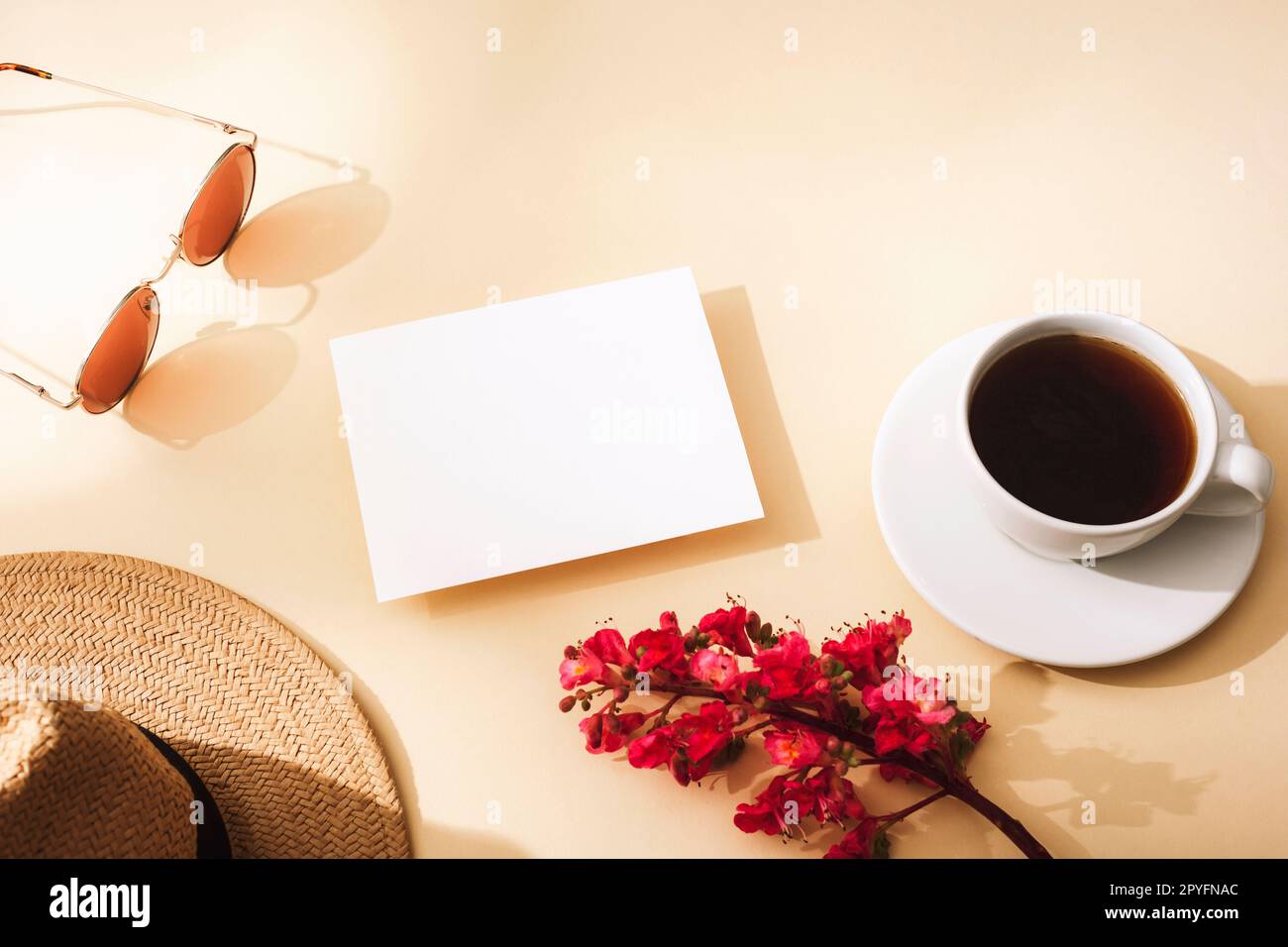 Blank card, coffee cup, straw hat, sunglasses and flower. Top view, flat lay Mockup Stock Photo