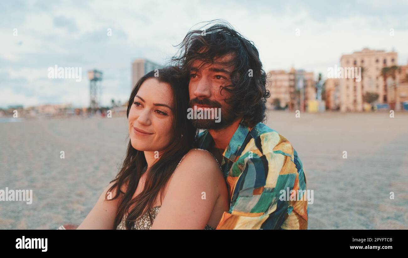 Man and woman hugging each other by the beach and watching the dawn ...