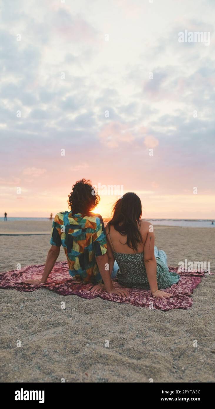 Man and woman hugging each other by the beach and watching the dawn ...