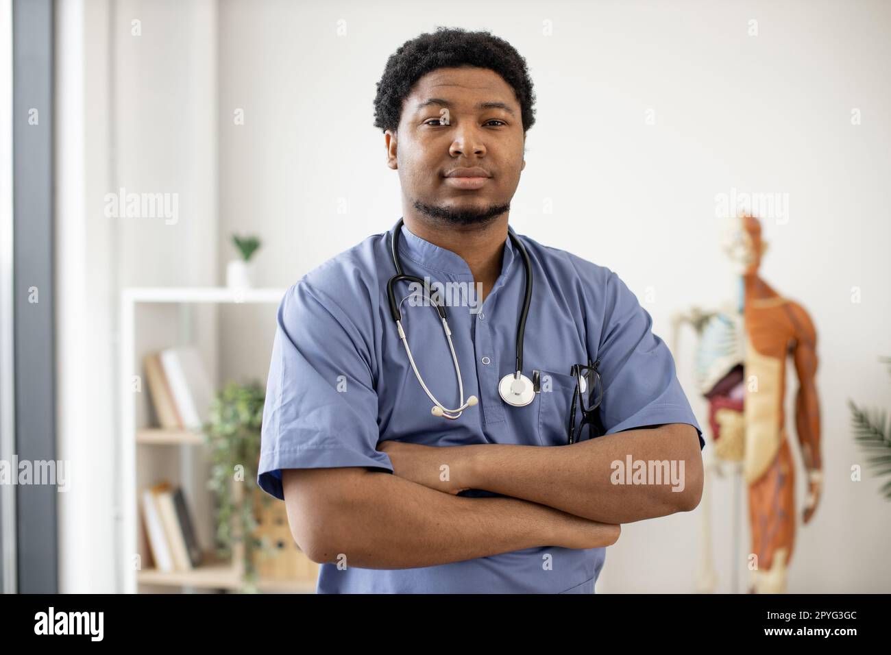 Handsome multiracial male specialist wearing blue scrubs and
