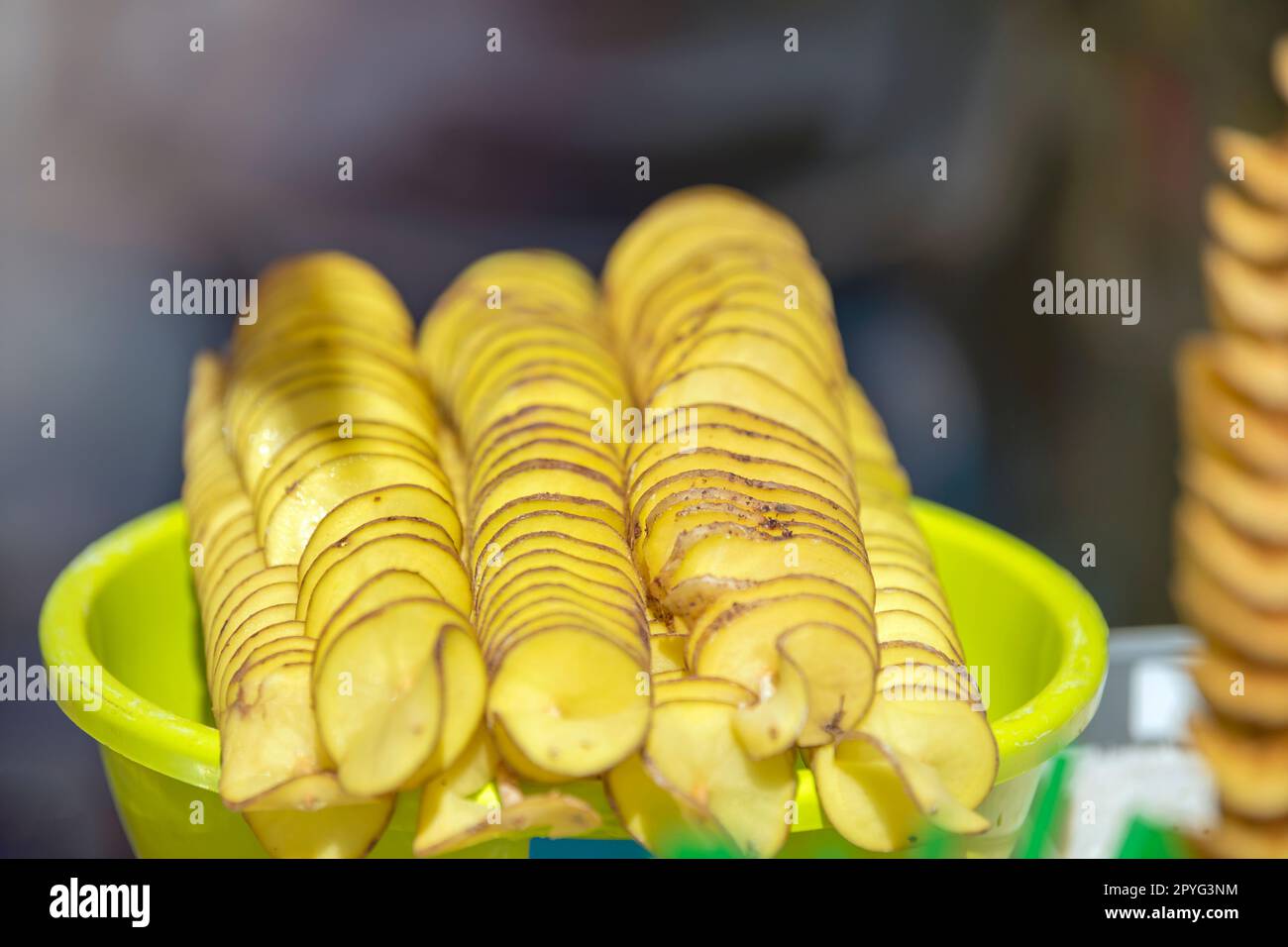 The process of making potato chips at home. Potato finely chopped into thin slices for further