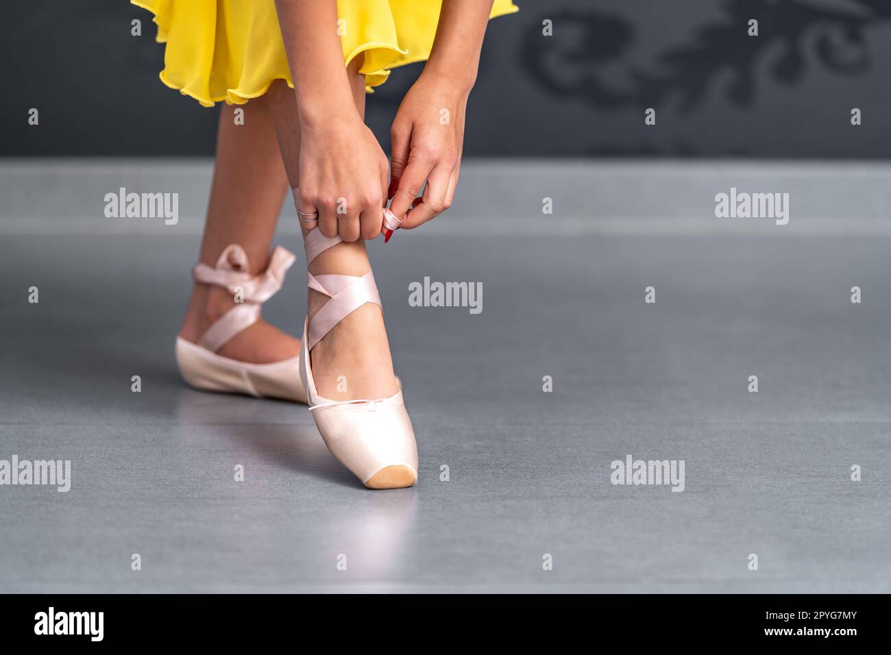 lacing of ballet shoes on the feet of a ballerina Stock Photo