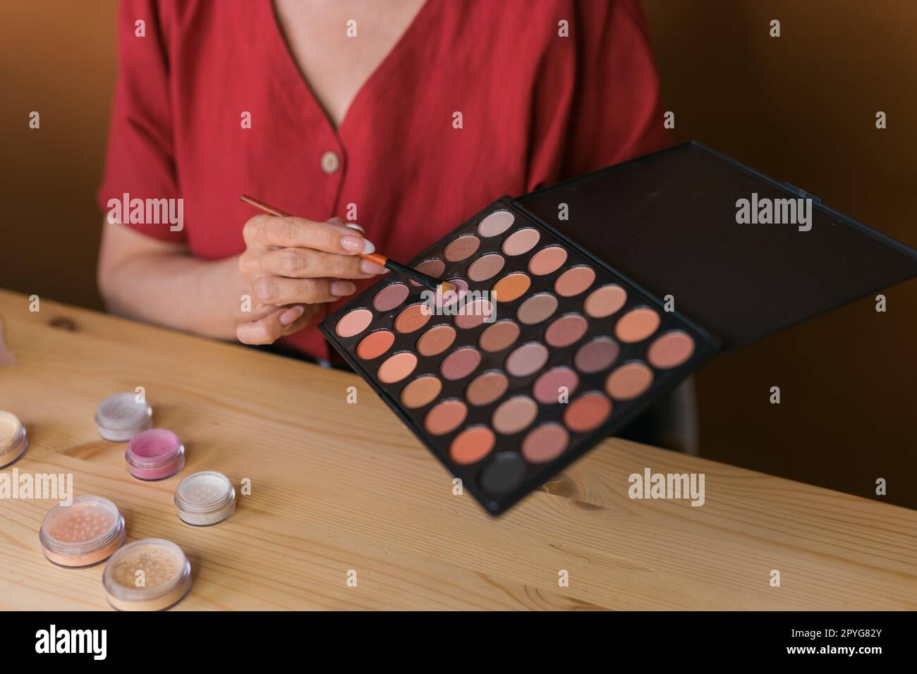 Close-up of woman holding makeup brush and blush and eyeshadow palette - beauty and cosmetics concept Stock Photo