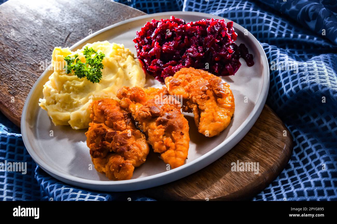 Breaded chicken cutlets served with potatoes and beetroot Stock Photo