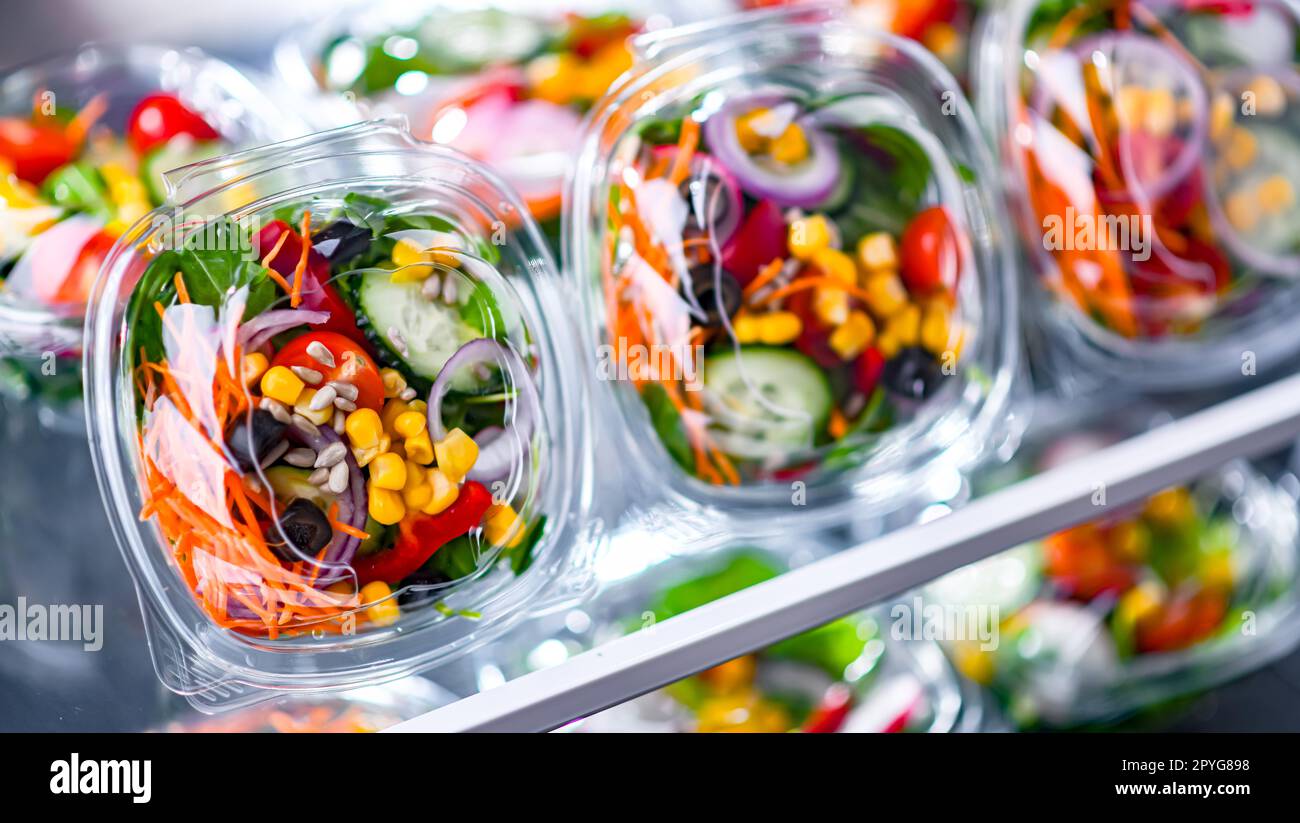 Boxes with prepackaged vegetable salads in a commercial fridge Stock