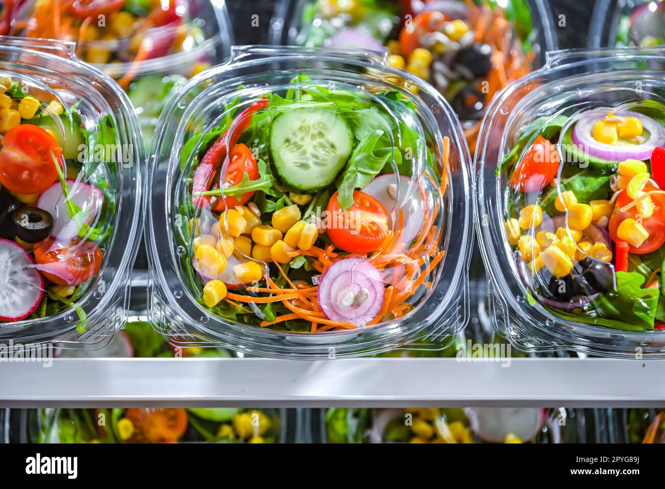 Boxes with prepackaged vegetable salads in a commercial fridge Stock