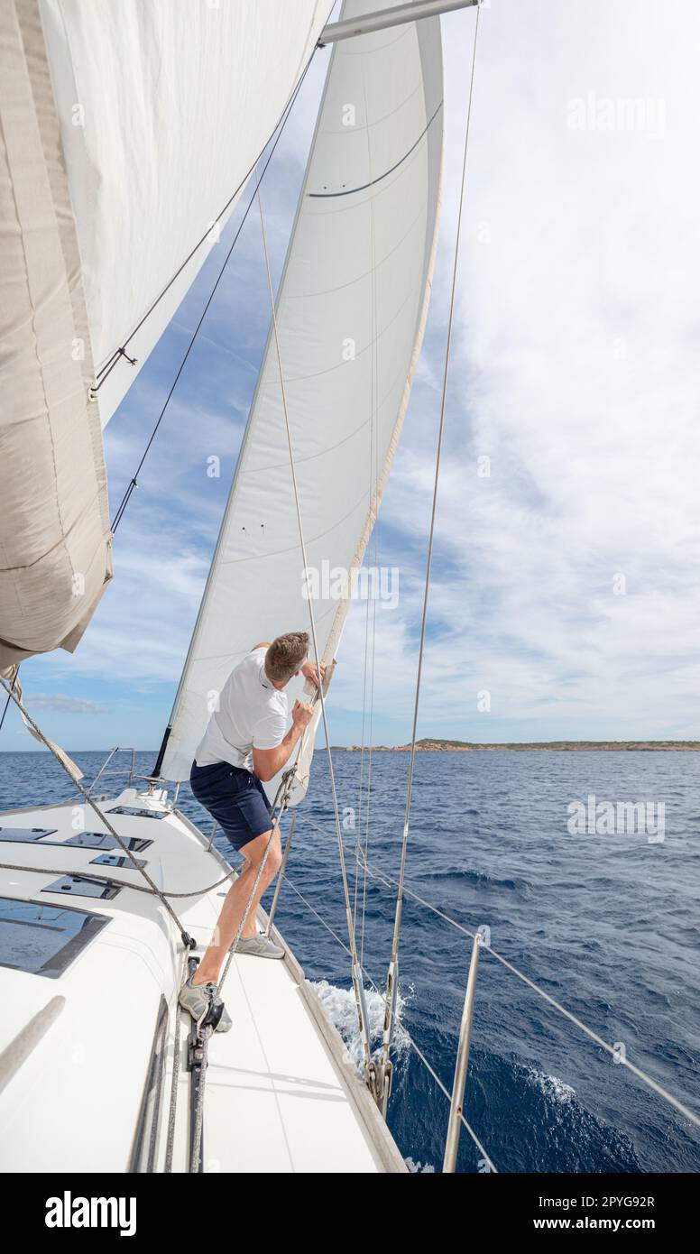 Man setting sail on his boat Stock Photo