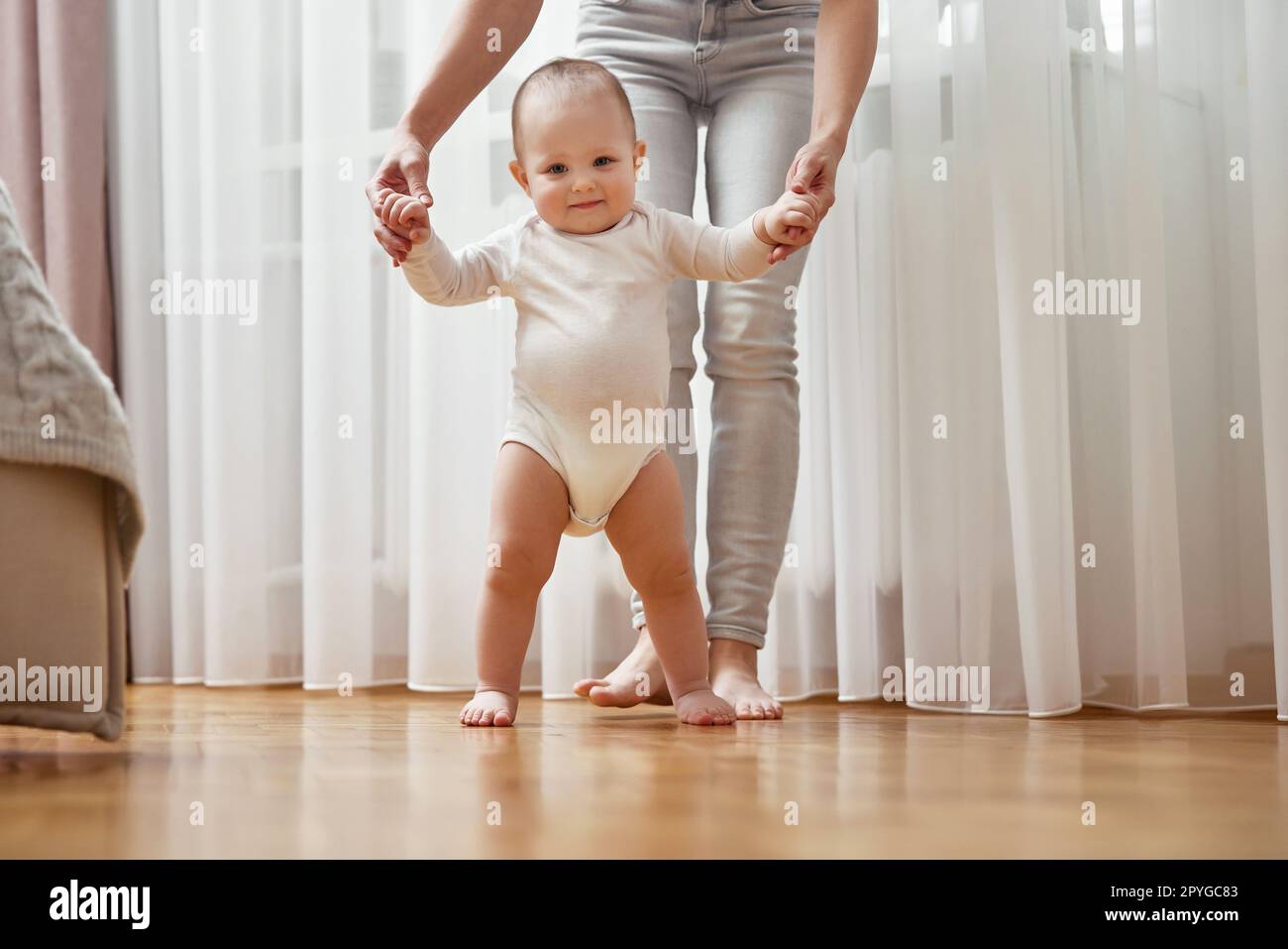 happy little baby girl learning to walk with mother help Stock Photo