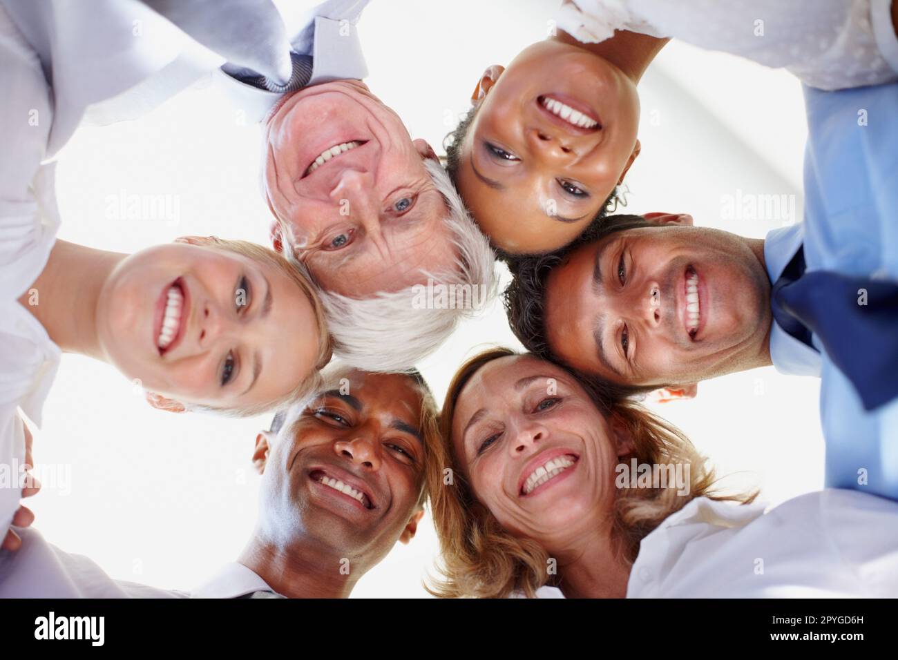 Teamwork. Low angle view of multi ethnic business group in huddle at office. Stock Photo