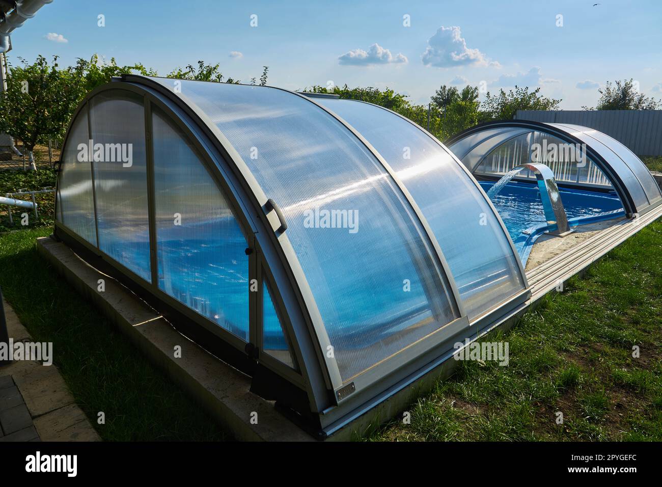 Outdoor swimming pool with sliding cover. Weather protection Stock Photo