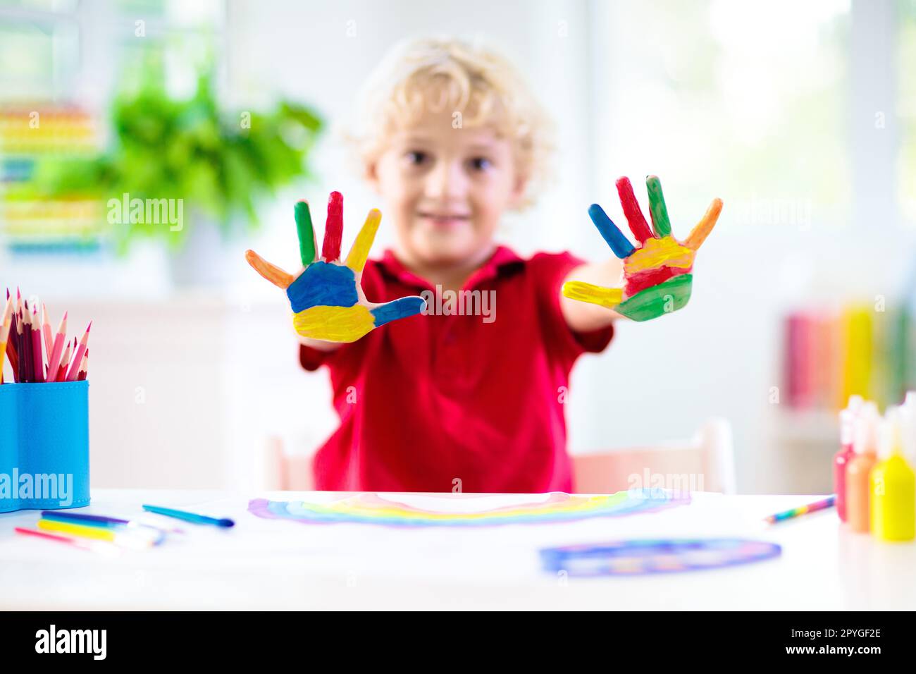 Kids paint. Child painting in white sunny study room. Little boy