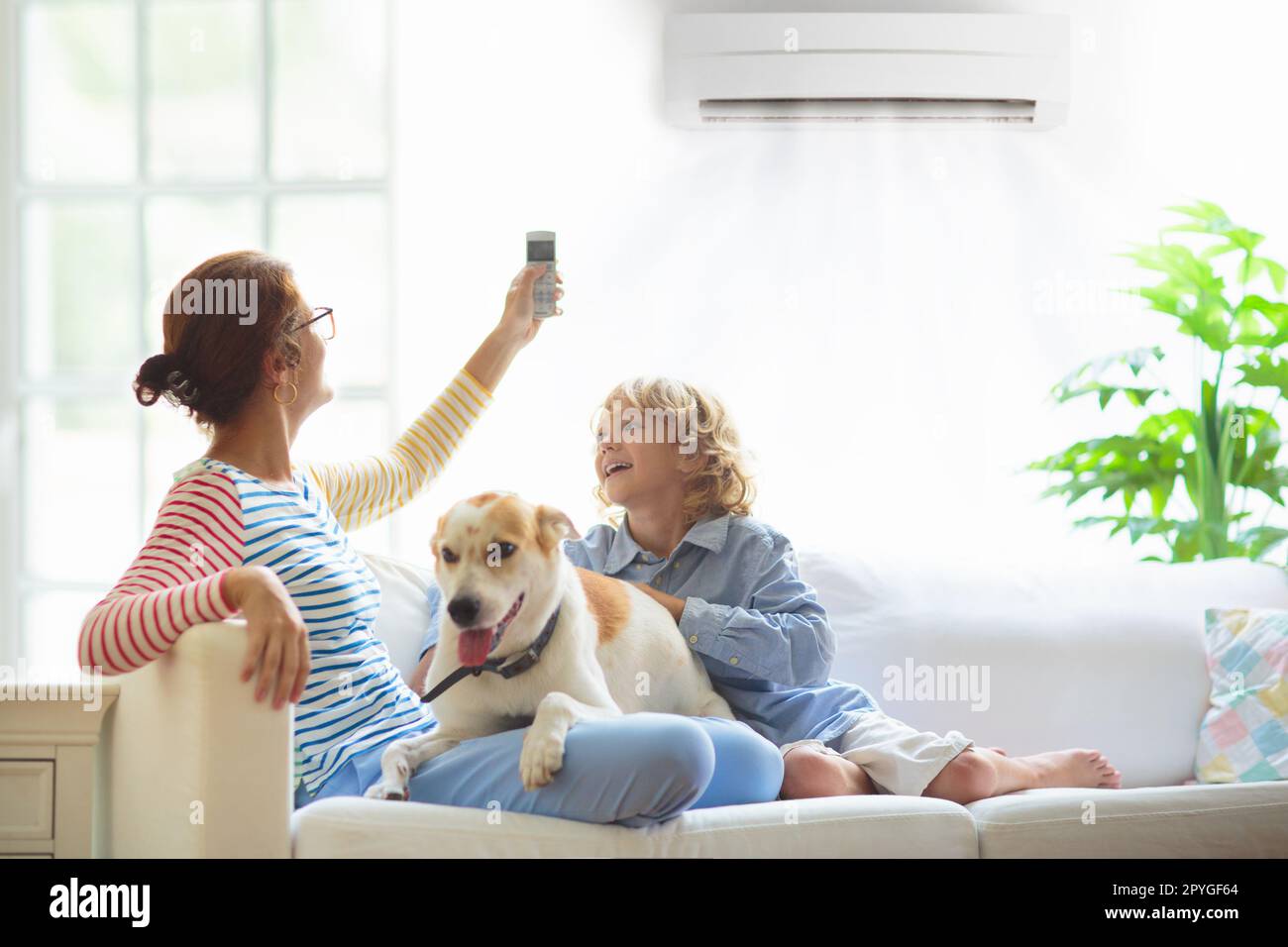 Mother and child with air conditioner remote control. Comfortable