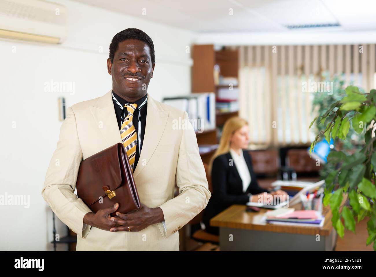 African american man in light business suit with portfolio in office ...